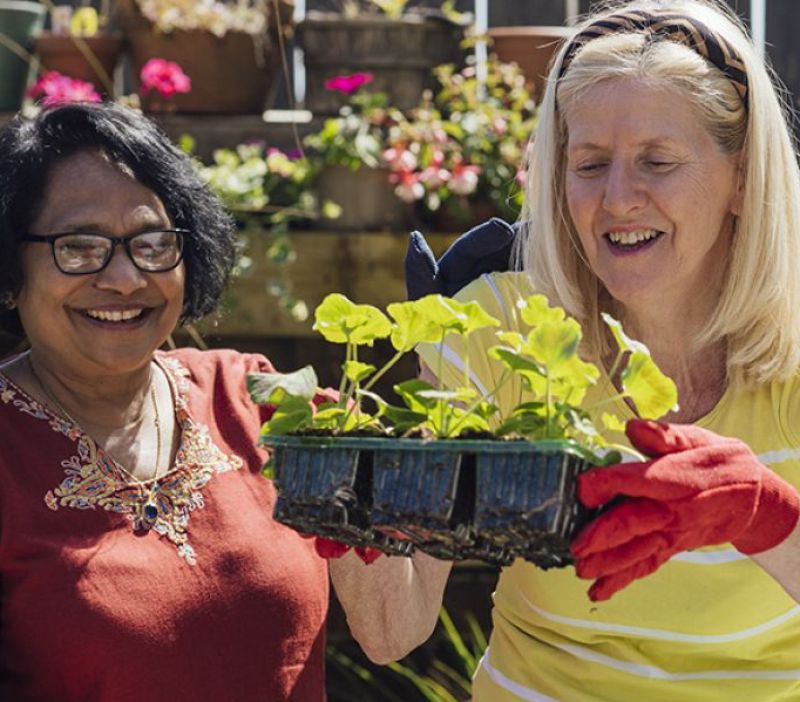 two women holding a tray of seedlings ready for potting